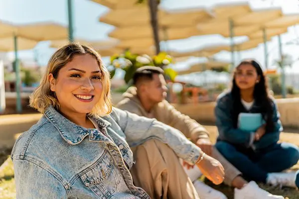 Portrait of a young woman with friends outdoors